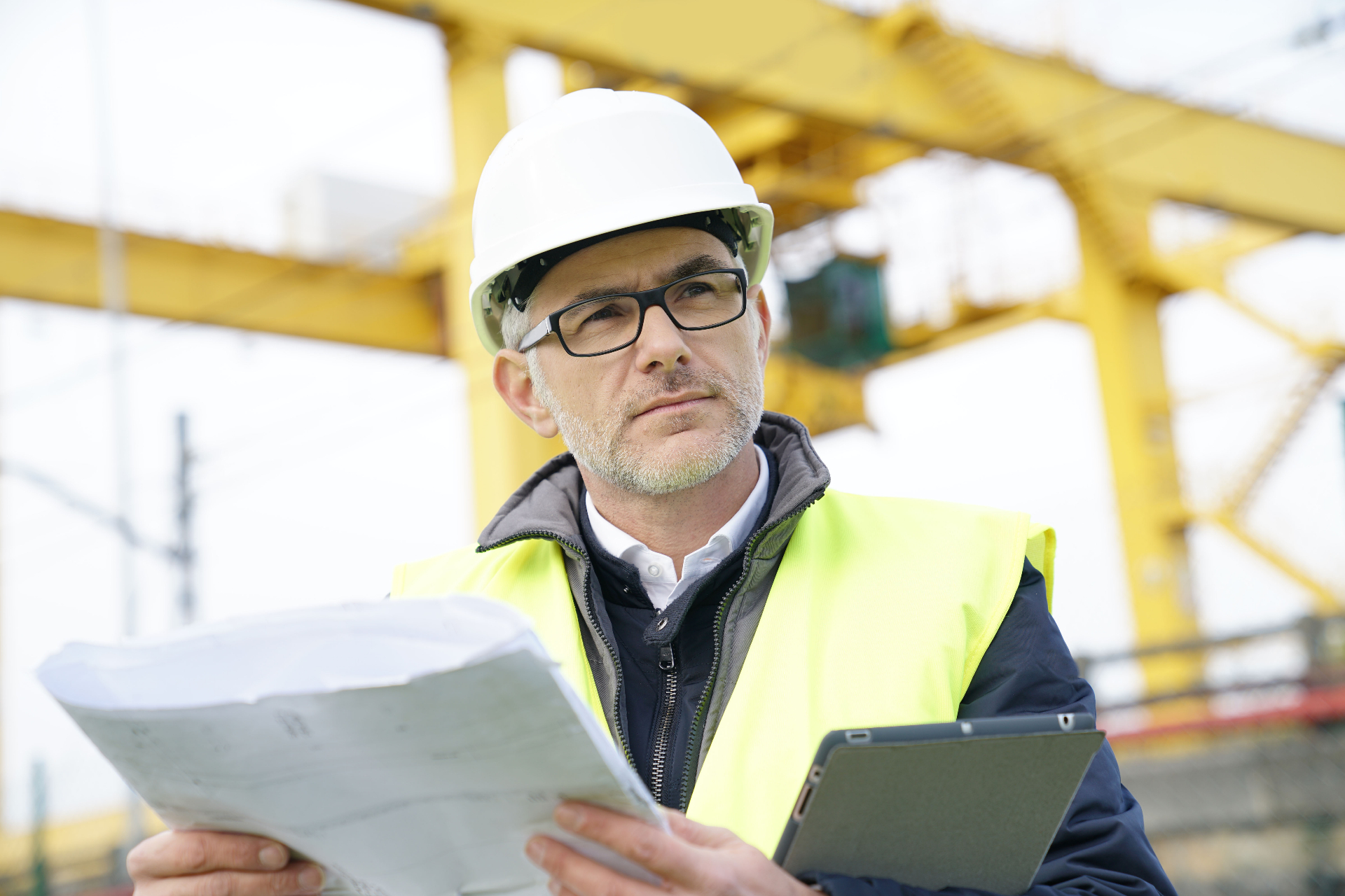 Field assessor reviewing site documentation in a safety-critical environment