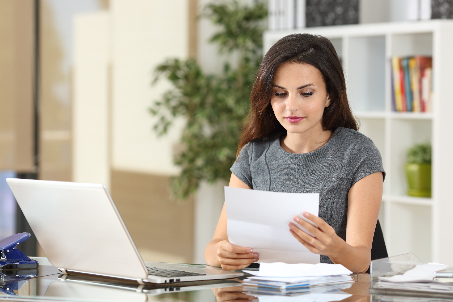 Professional reviewing certification correspondence at her desk